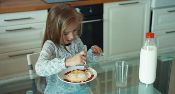 Niño comiendo huevos y mirando a la cámara — Vídeos de Stock