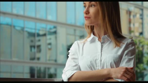 Sluit portret van een jong volwassen vrouw in een witte blouse camera kijken. Zoomen — Stockvideo