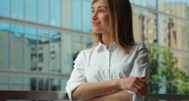 Nauwe portret van een jong volwassen vrouw in een witte blouse camera kijken — Stockvideo