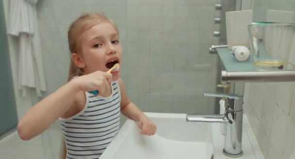 Meisje tanden reinigen na de maaltijd en lachen om camera — Stockvideo