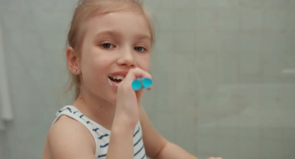 Close up retrato menina limpeza dentes após as refeições e olhando para a câmera — Vídeo de Stock