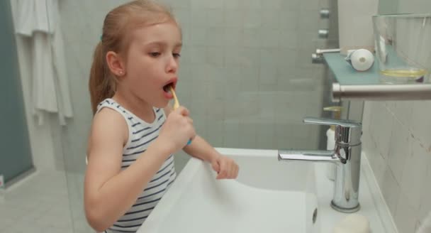 Menina limpeza dos dentes após as refeições e olhando para a câmera — Vídeo de Stock