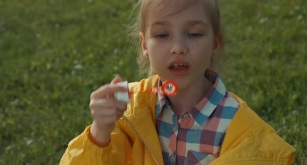 Closeup portret meisje blazen van zeepbellen en lachen om de camera — Stockvideo