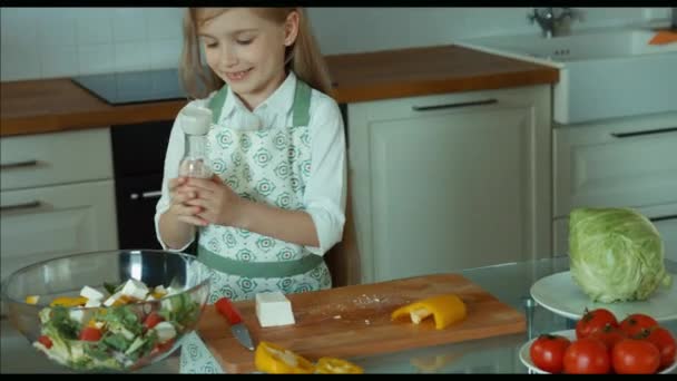 Ensalada de chica espolvorea sal. Niño chef en la cocina. Ampliación — Vídeos de Stock