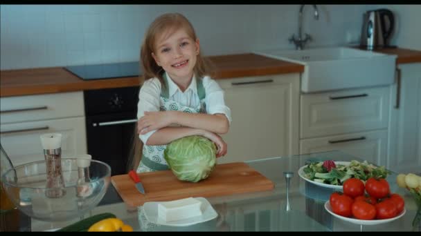 Śmiejąc się dziewczyna kucharz w kuchni, patrząc na kamery. Powiększanie — Wideo stockowe