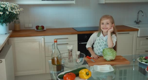Dziewczyna kucharz w kuchni, patrząc na kamery i uśmiecha się. Kciuk w górę. Ok — Wideo stockowe