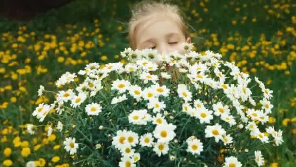 クローズ アップの肖像画の子と白い花の大きい花束。カメラ目線と笑顔の子。ズーム — ストック動画