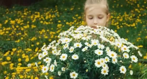 Gros plan portrait fille riante et grand bouquet de fleurs blanches. Enfant regardant la caméra et souriant — Video