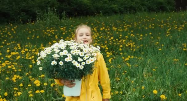 Niño feliz y gran ramo de flores blancas. La chica está en el prado con flores. Pulgar hacia arriba. Ok. — Vídeos de Stock