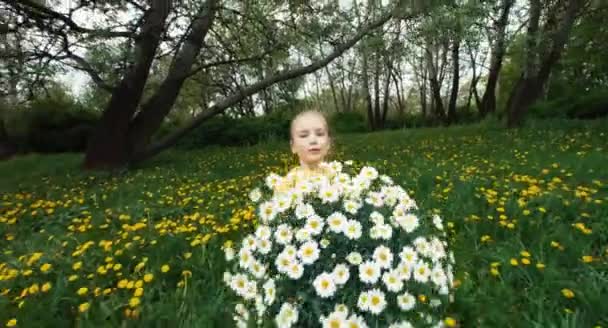 Niño feliz y gran ramo de flores blancas. Chica está en el prado con flores — Vídeo de stock