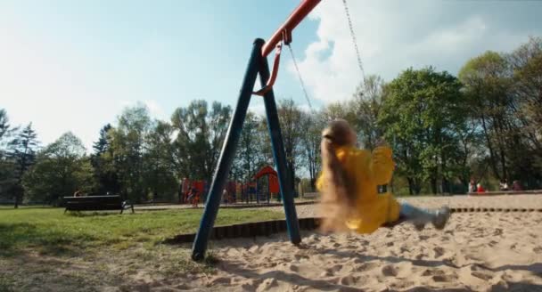 Preschooler jízda na houpačce v parku — Stock video