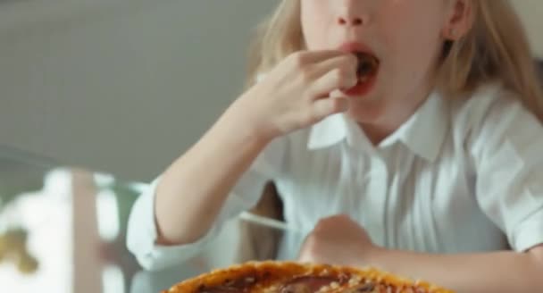 Kind eet een paddestoel van pizza. Glimlachend in de camera. Duim omhoog. OK — Stockvideo