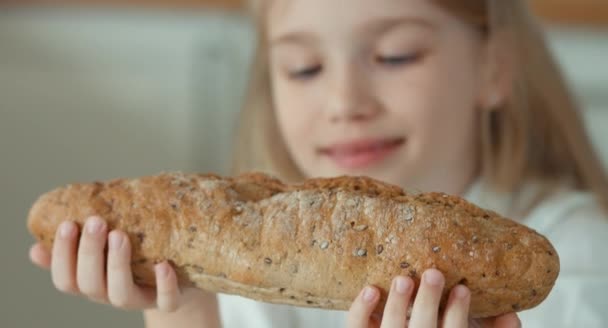 Nahaufnahme Porträt Mädchen riecht ein Brot und bewundert sie — Stockvideo