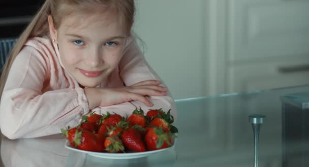 Retrato de cerca de la hermosa chica y un gran plato de fresas — Vídeo de stock