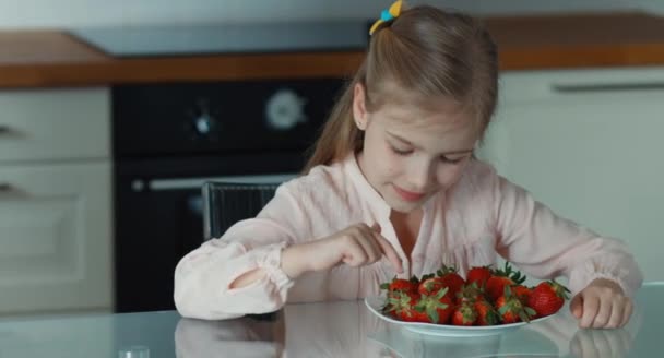 Duimen omhoog. OK. Mooi kind meisje en een grote plaat van aardbeien. Kind lloking op camera en glimlachen — Stockvideo