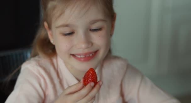 Rindo menina vê um grande morango vermelho — Vídeo de Stock