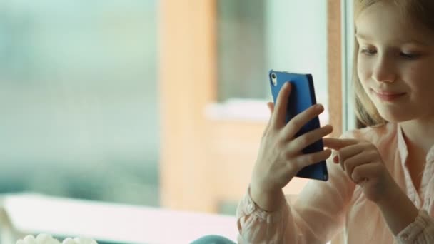 Closeup portrait child using mobile phone and smiling. Looking at camera. Shows ok. Thumbs up — Stock Video