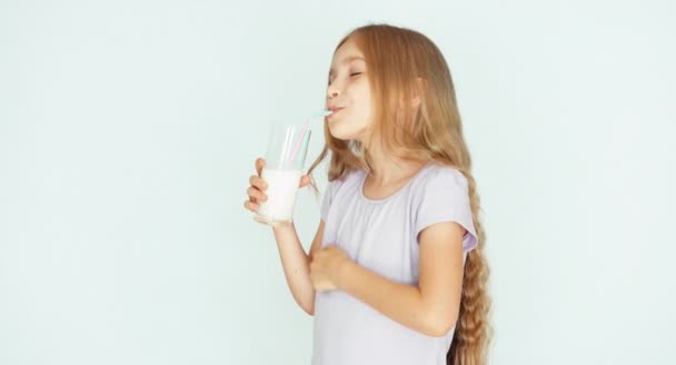Smiling child drinking milk. Girl with beautiful blond hair on a white  background. Thumb up. Ok — Stock Video © arundo #126602980