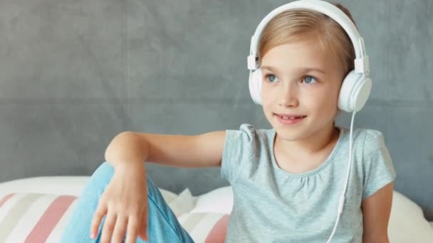 Chica riendo retrato escuchando música en auriculares blancos. Ampliación — Vídeos de Stock