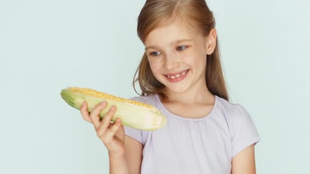 Niña mostrando maíz. Chica sosteniendo maíz en las manos. Pulgar hacia arriba. De acuerdo, de cerca. — Vídeos de Stock