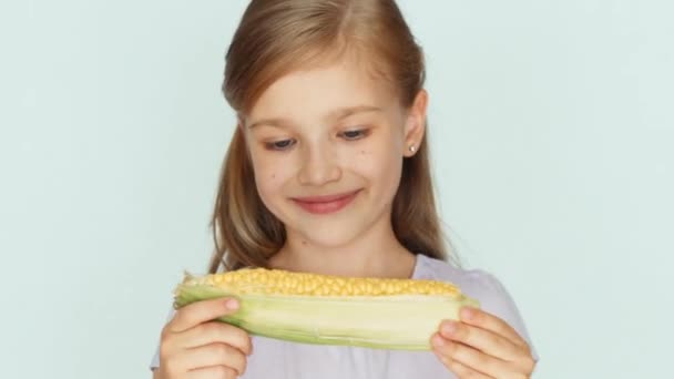 Child showing corn. Girl holding corn in the hands. Closeup — Stock Video