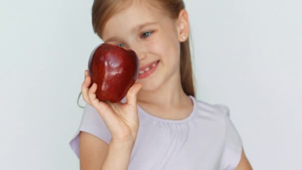 Niña mostrando manzana. Niña olfateando sosteniendo una manzana roja en la palma. Primer plano. — Vídeo de stock