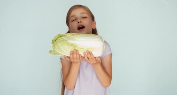 Дівчина нюхає капусту і показує — стокове відео