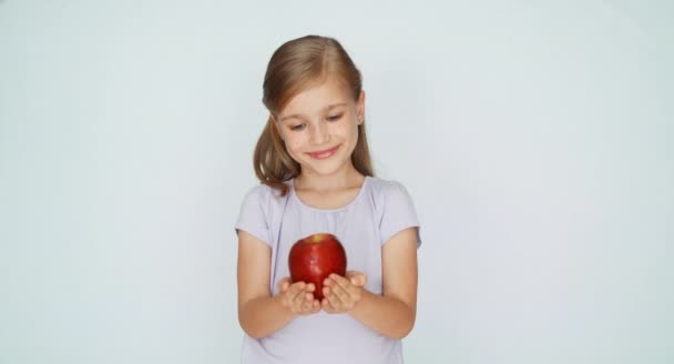 Девушка держит красное яблоко в ладони — стоковое видео