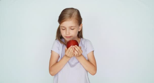 Kind zeigt roten Apfel. Mädchen hält einen roten Apfel in der Handfläche — Stockvideo