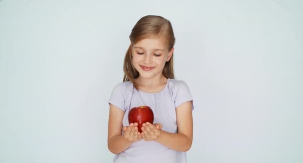 Ребенок показывает яблоко. Девушка держит красное яблоко в ладони — стоковое видео