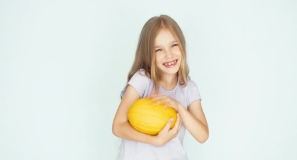 Mädchen spielt mit Melone und lacht in die Kamera auf weißem Hintergrund. Daumen hoch. ok — Stockvideo