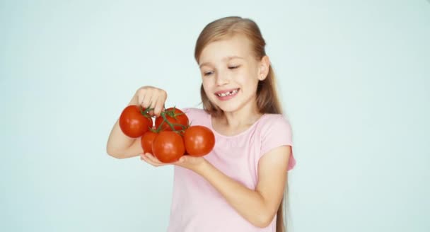 Chica olfateando tomates y riendo de la cámara en el fondo blanco. Pulgar hacia arriba. Ok. — Vídeos de Stock