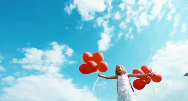 Meisje loslaten ballonnen vliegen in de lucht. Gelukkig kind zwaaiende hand — Stockvideo