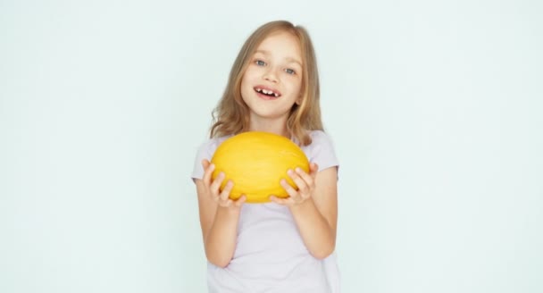 Chica oliendo melón y mostrando la baya y riendo de la cámara — Vídeos de Stock