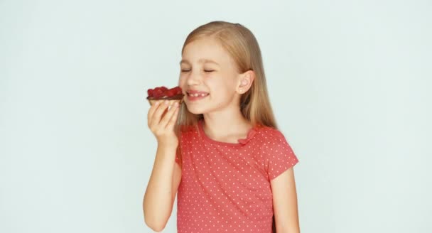 Meisje holding en snuiven een cake met frambozen. Close-up. Duim omhoog. OK — Stockvideo