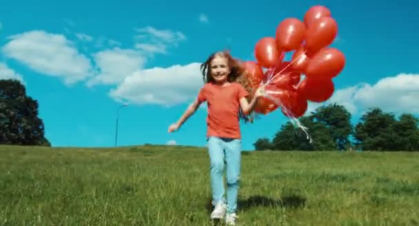 Ritratto ragazza con palloncini rossi a piedi alla macchina fotografica — Video Stock