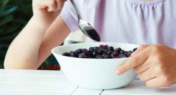 Girl eating blueberries with sugar. Closeup. Big eyes. Thumb up. Ok — Stockvideo