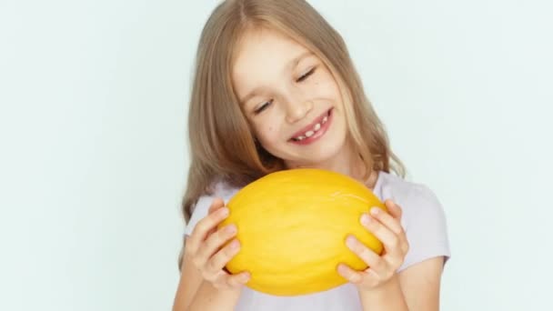 Girl playing with melon and laughing at camera on the white background. Closeup — Stockvideo