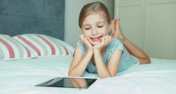 Dívka pomocí počítače tablet pc a ležel na posteli — Stock video
