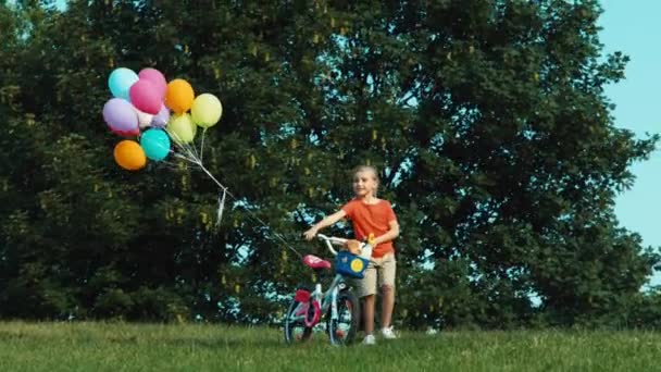 小女孩走在公园的自行车。篮子里的面包和牛奶。缩放 — 图库视频影像