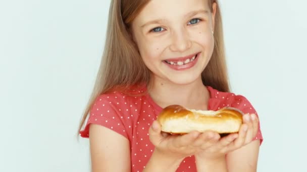 Mädchen hält eine Torte mit Käse und zeigt sie in die Kamera. Kind auf weißem Hintergrund. Nahaufnahme — Stockvideo
