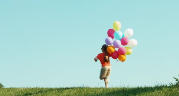 Girl dressed in shorts and a T-shirt turned around with balloons — Stock video