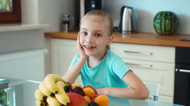 La ragazza fa pubblicità alla frutta. Bambino che guarda la macchina fotografica e sorride. Zoomare — Video Stock