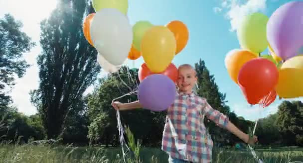 Игривая девушка-портрет, идущая на камеру с воздушными шарами в парке — стоковое видео
