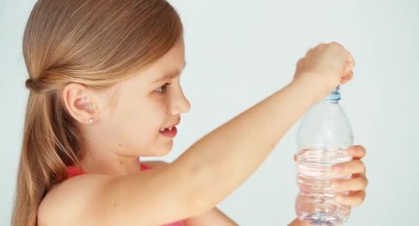 Girl child drinking water from bottle at camera — Stock Video