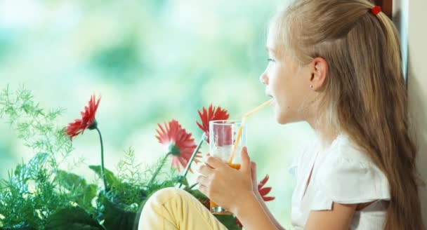 Πορτρέτο κορίτσι πίνοντας χυμό κατά το λουλούδι — Αρχείο Βίντεο