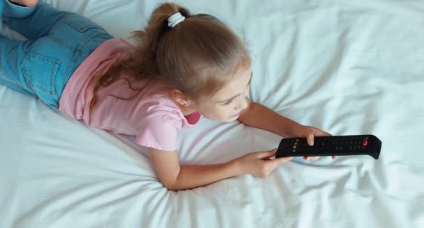 Κορίτσι βλέποντας τηλεόραση ξαπλωμένη στο κρεβάτι. Το Top view — Αρχείο Βίντεο
