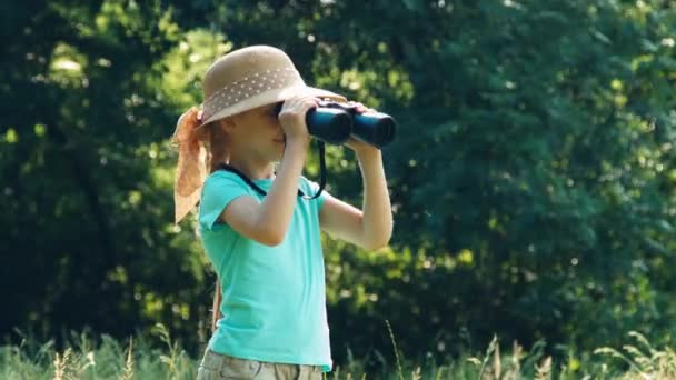 Meisje is naturalist explorer op zoek door middel van verrekijkers op de camera en lachen. Zoomen — Stockvideo