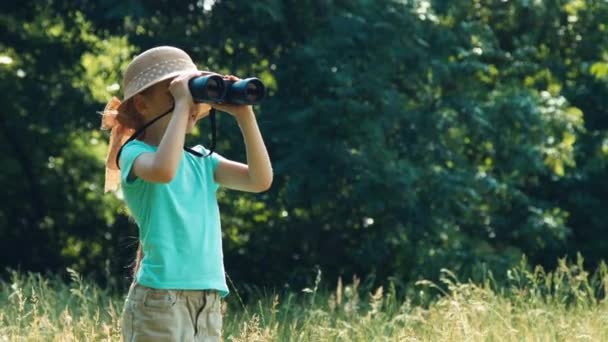 Portret dziewczyny przyrodnik explorer patrząc przez lornetki o odległość i śmiejąc się na aparat. Powiększanie — Wideo stockowe