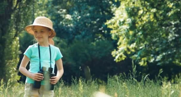 Mädchen hält Fernglas in der Hand und blickt in Kamera — Stockvideo